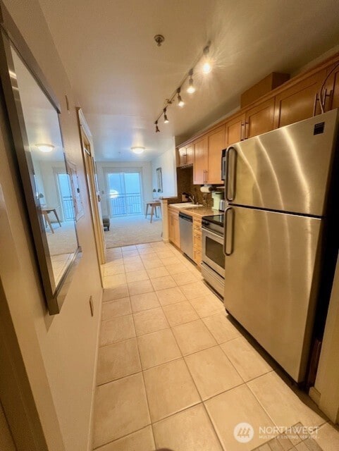 326 Queen Anne Ave N Unit 502, Seattle, WA 98109 - kitchen featuring a sink, appliances with stainless steel finishes, light tile patterned floors, and light countertops