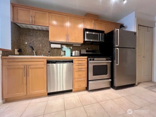 326 Queen Anne Ave N Unit 502, Seattle, WA 98109 - kitchen with a sink, tasteful backsplash, light tile patterned flooring, and stainless steel appliances