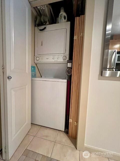 326 Queen Anne Ave N Unit 502, Seattle, WA 98109 - clothes washing area with stacked washer and clothes dryer, light tile patterned flooring, and laundry area