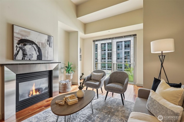 living area featuring a glass covered fireplace and wood finished floors