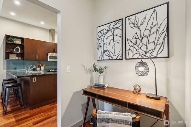 interior space featuring recessed lighting, a sink, and wood finished floors