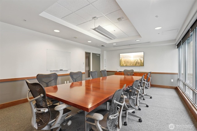 office space featuring carpet floors, baseboards, a tray ceiling, and visible vents