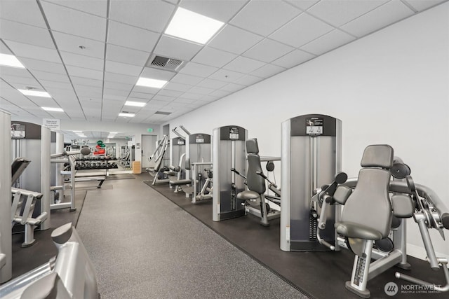 workout area featuring arched walkways, visible vents, and a paneled ceiling