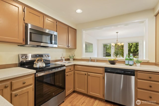 2003 Mill Pointe Dr SE, Mill Creek, WA 98012 - kitchen featuring stainless steel appliances, light countertops, recessed lighting, a sink, and light wood-style flooring