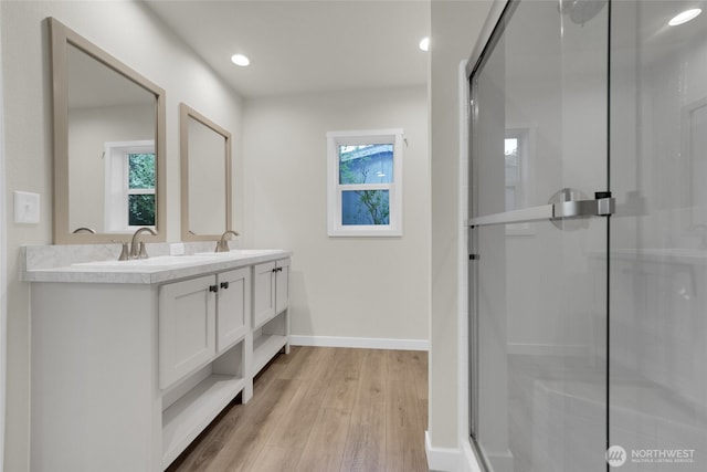 13105 Ridge Cir E, Bonney Lake, WA 98391 - bathroom with double vanity, baseboards, wood finished floors, and a shower stall