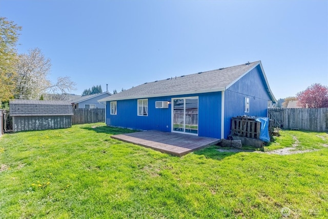 back of property featuring a shed, a fenced backyard, a wall unit AC, an outbuilding, and a lawn