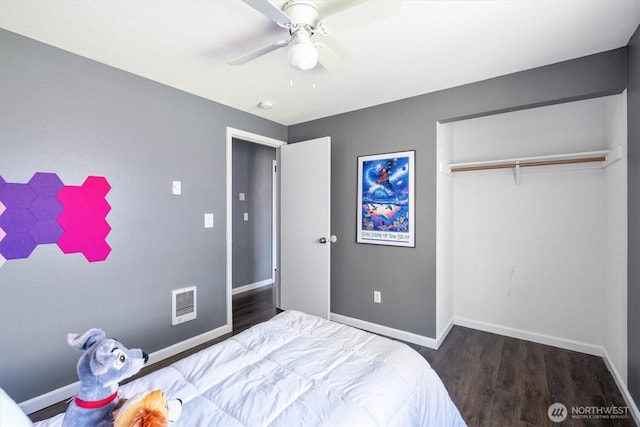 bedroom with visible vents, a closet, baseboards, and wood finished floors