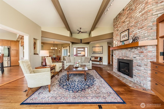 6250 Woodcock Rd, Sequim, WA 98382 - living room featuring wood finished floors, a fireplace, and a chandelier