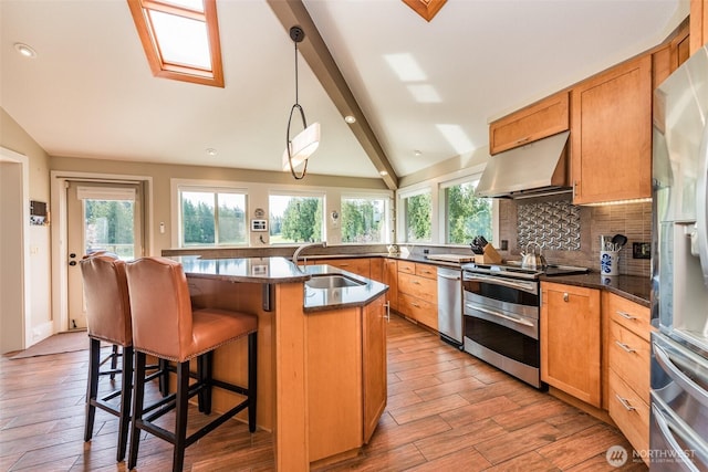 6250 Woodcock Rd, Sequim, WA 98382 - kitchen featuring appliances with stainless steel finishes, under cabinet range hood, light wood finished floors, backsplash, and recessed lighting