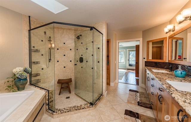 6250 Woodcock Rd, Sequim, WA 98382 - full bathroom with a stall shower, a bath, a skylight, double vanity, and tile patterned flooring