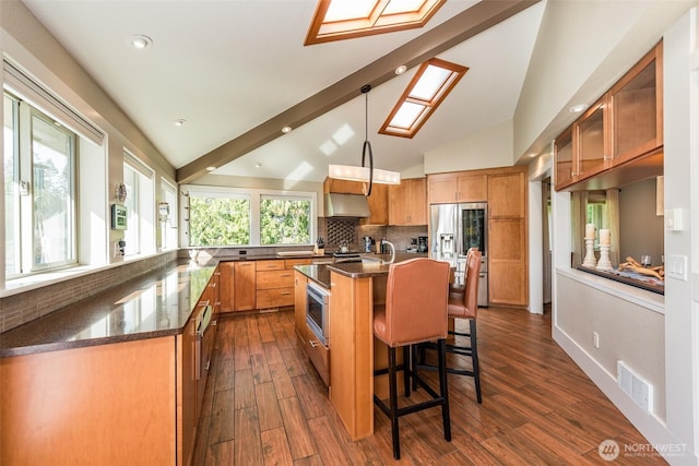 6250 Woodcock Rd, Sequim, WA 98382 - kitchen featuring stainless steel appliances, a skylight, a breakfast bar area, vaulted ceiling, and tasteful backsplash