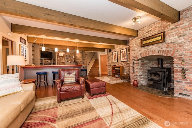 6250 Woodcock Rd, Sequim, WA 98382 - living area featuring a wood stove, a dry bar, wood finished floors, beam ceiling, and stairway