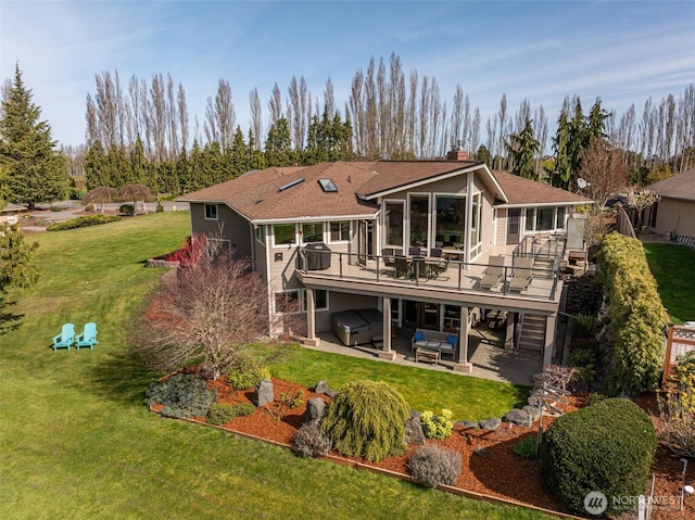 6250 Woodcock Rd, Sequim, WA 98382 - back of property featuring a hot tub, a patio, a wooden deck, a chimney, and a lawn