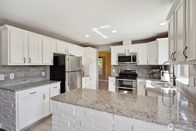 24214 38th Avenue Ct E, Spanaway, WA 98387 - kitchen featuring appliances with stainless steel finishes, a sink, light stone countertops, decorative backsplash, and recessed lighting