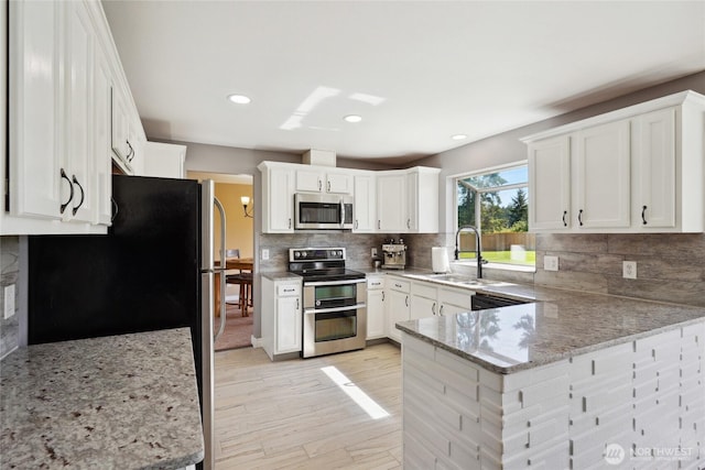 24214 38th Avenue Ct E, Spanaway, WA 98387 - kitchen featuring stainless steel appliances, a sink, a peninsula, backsplash, and recessed lighting