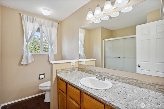 24214 38th Avenue Ct E, Spanaway, WA 98387 - bathroom featuring baseboards, vanity, a stall shower, wood finished floors, and toilet
