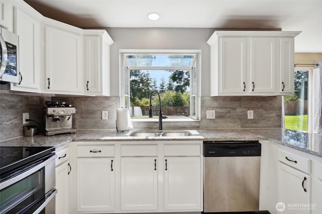 24214 38th Avenue Ct E, Spanaway, WA 98387 - kitchen featuring stainless steel appliances, a sink, white cabinets, tasteful backsplash, and light stone counters