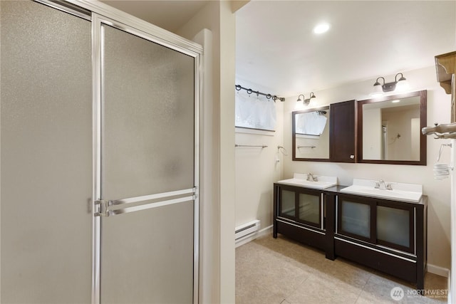 full bath featuring a baseboard radiator, a sink, a stall shower, and tile patterned floors