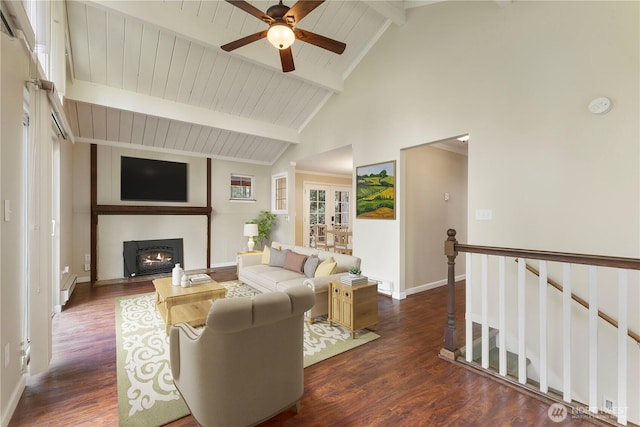 living area with dark wood-type flooring, ceiling fan, beam ceiling, and a lit fireplace