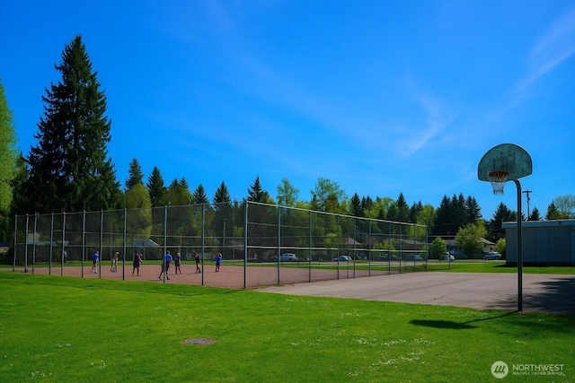 view of property's community featuring a lawn and fence