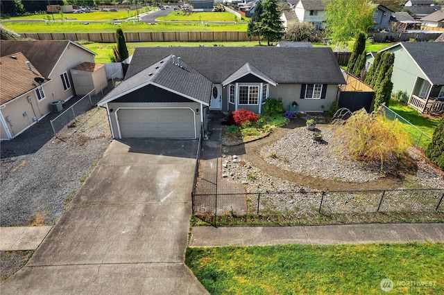 view of front of home featuring a residential view, fence private yard, an attached garage, and driveway