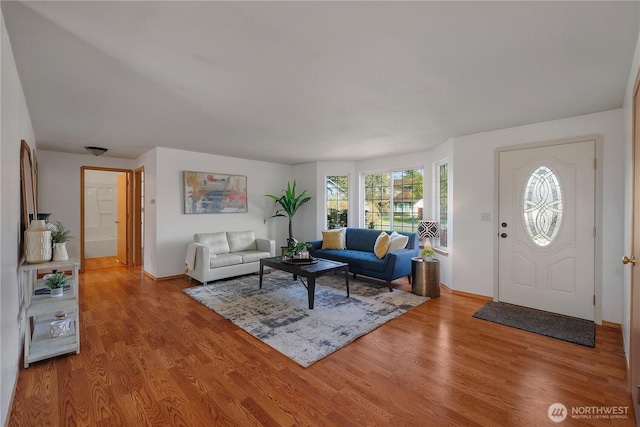 living area with baseboards and wood finished floors