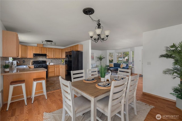 dining area with a chandelier and light wood-style flooring