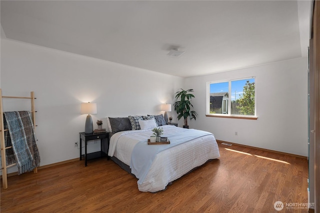 bedroom with baseboards and wood finished floors