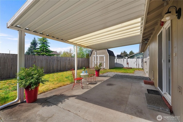 view of patio / terrace with a fenced backyard, a shed, and an outbuilding