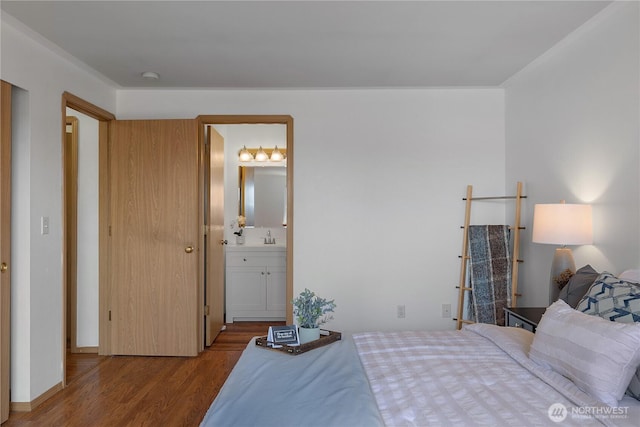 bedroom featuring a sink, wood finished floors, and connected bathroom