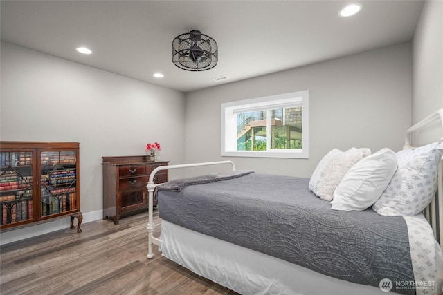 bedroom with wood finished floors, recessed lighting, and baseboards