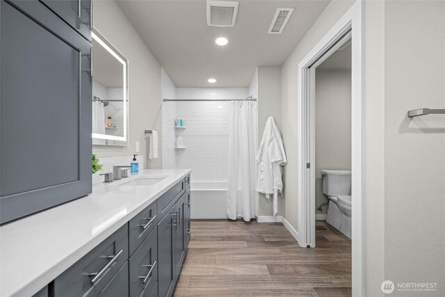 full bathroom featuring vanity, wood finished floors, recessed lighting, toilet, and baseboards