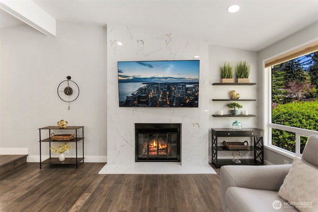 living room featuring recessed lighting, a premium fireplace, wood finished floors, and baseboards