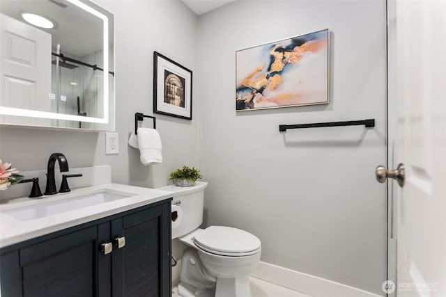 bathroom with a shower stall, toilet, and vanity