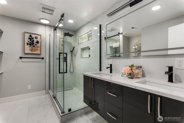 bathroom featuring visible vents, marble finish floor, a stall shower, and a sink