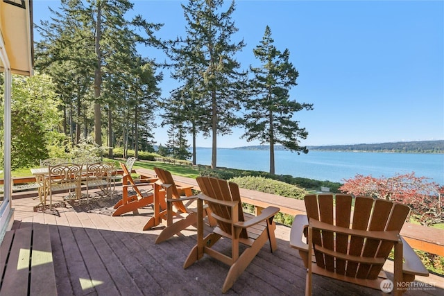 deck featuring outdoor dining area and a water view