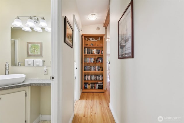 hallway with a sink and light wood-style floors