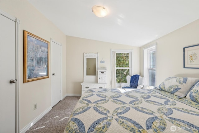 carpeted bedroom featuring vaulted ceiling and baseboards