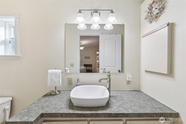 bathroom with vanity, connected bathroom, and toilet