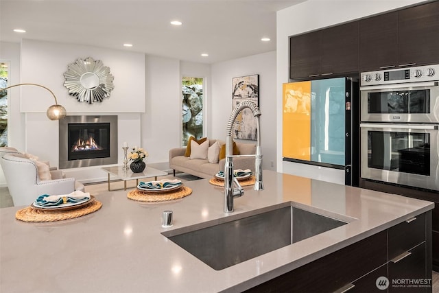 16515 26th St E, Lake Tapps, WA 98391 - kitchen with a sink, open floor plan, stainless steel double oven, refrigerator, and a glass covered fireplace