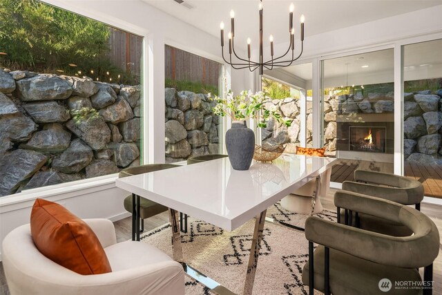16515 26th St E, Lake Tapps, WA 98391 - dining space featuring wood finished floors, a lit fireplace, and a chandelier