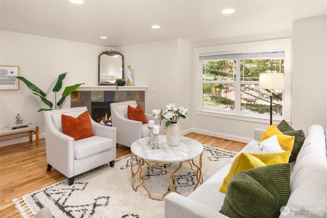 5235 11th Ave NE Unit A, Seattle, WA 98105 - living room with wood finished floors, a tiled fireplace, recessed lighting, and baseboards