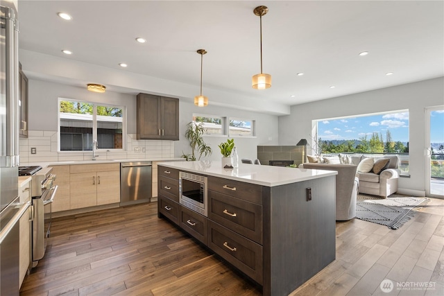 9028 45th Ave NE, Seattle, WA 98115 - kitchen with backsplash, dark brown cabinets, dark wood-style flooring, and stainless steel appliances