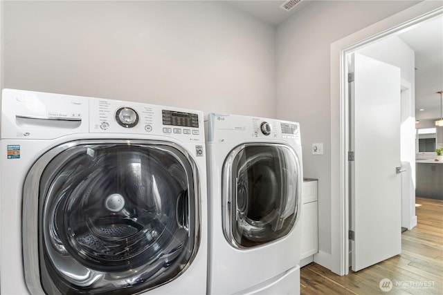 9028 45th Ave NE, Seattle, WA 98115 - laundry area featuring wood finished floors, laundry area, and separate washer and dryer