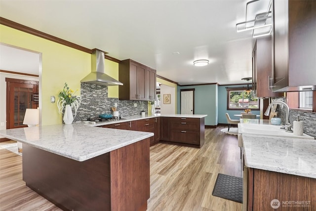 3718 NE Everett St, Camas, WA 98607 - kitchen with a peninsula, range hood, decorative backsplash, light wood finished floors, and ornamental molding