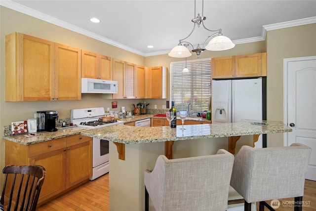 kitchen with white appliances, crown molding, a center island, light wood-style floors, and recessed lighting