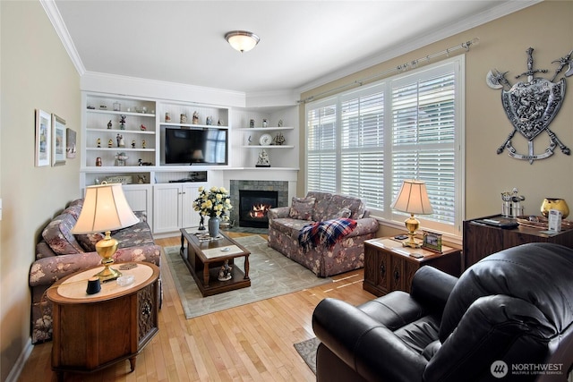 living room with light wood finished floors, ornamental molding, and a fireplace with flush hearth