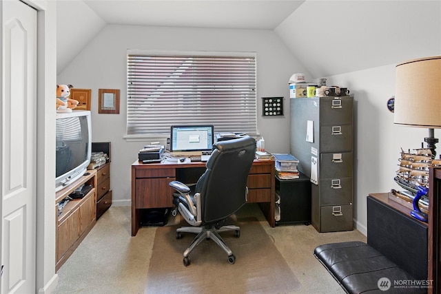 office space with lofted ceiling, light carpet, and baseboards
