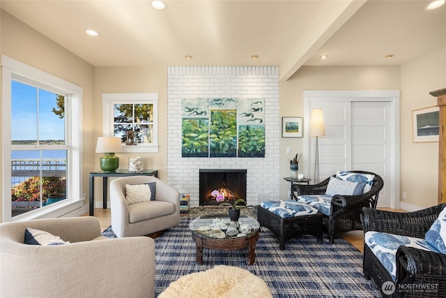 10915NE S Beach Rd, Bainbridge Island, WA 98110 - living room featuring a brick fireplace, recessed lighting, dark wood-style flooring, a water view, and baseboards