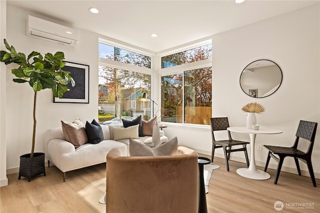 living area with baseboards, light wood-type flooring, recessed lighting, and a wall unit AC